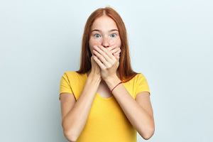 Woman covering her mouth in shock