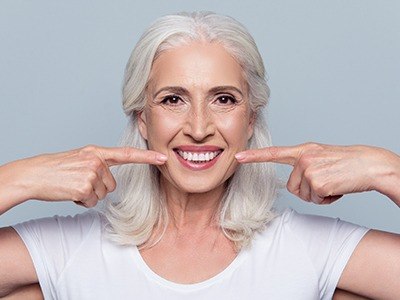 Woman pointing to her smile