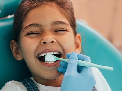 Little girl laughing in dental chair