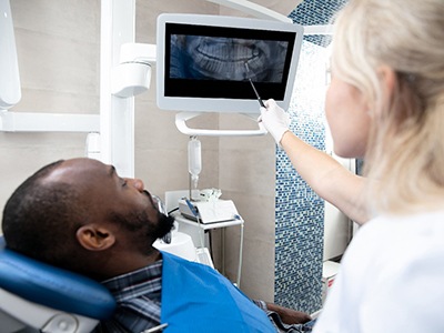 a dentist showing a patient their X-rays