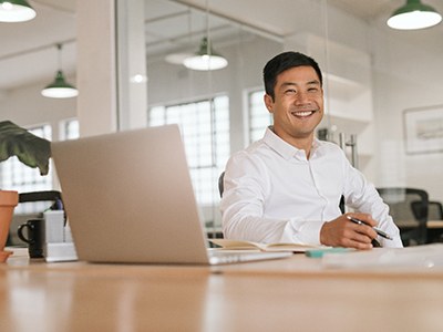 a person sitting at their desk at work and smiling