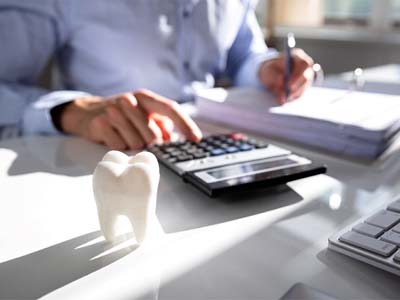 Dental patient calculating cost of dentures in Fort Worth