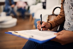 Patient filling out form on clipboard