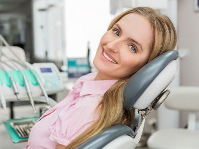 A smiling woman in dental chair