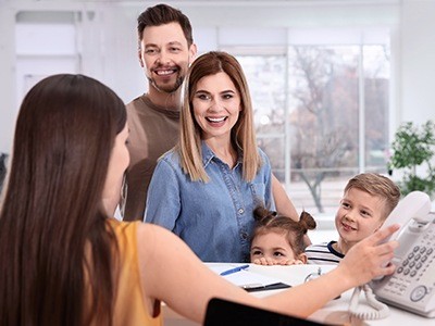 Family at front desk of dental office