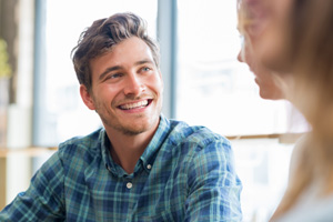 Man in blue plaid shirt smiling at friends