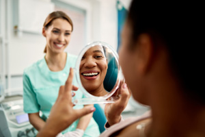 Patient smiling at reflection in treatment chair