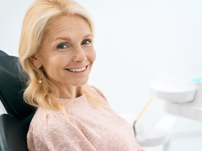 a patient smiling after undergoing the dental implant process