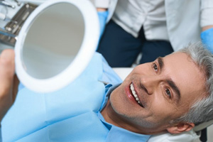 a patient checking his smile with a mirror