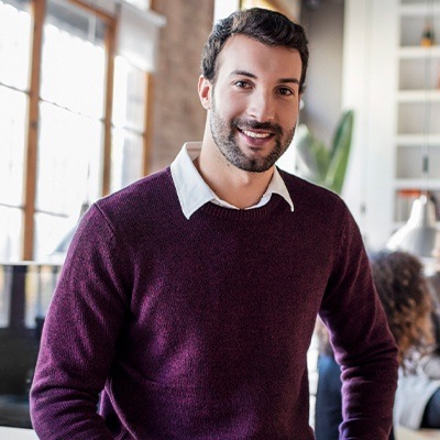 Man in maroon sweater smiling after preventive dentistry in Fort Worth