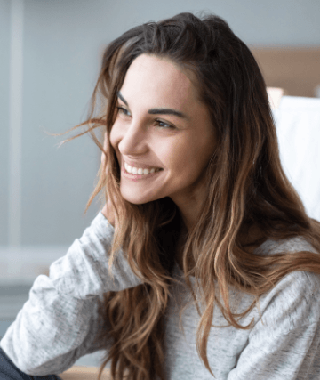 woman sitting in bed smiling