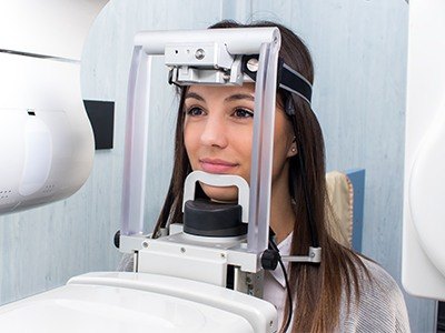 Woman receiving 3 D cone beam imaging of her jaw and mouth