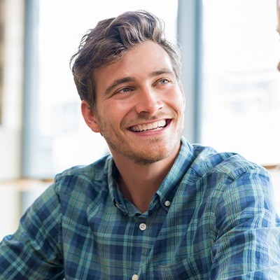 Man in plaid shirt smiling with dental veneers in Fort Worth