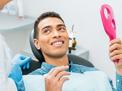 man looking at smile in pink mirror