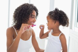 mom and daughter brushing teeth