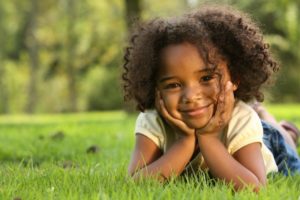 little girl hands on face smiling