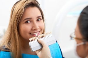 young woman replacing veneers at her dentist’s office