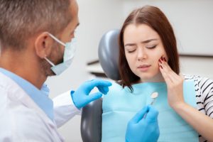 a woman visiting her dentist regarding her facial pain