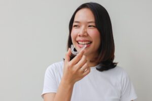 Woman smiling while putting in her Invisalign