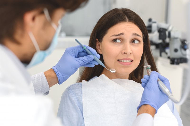 An anxious woman about to receive a teeth cleaning